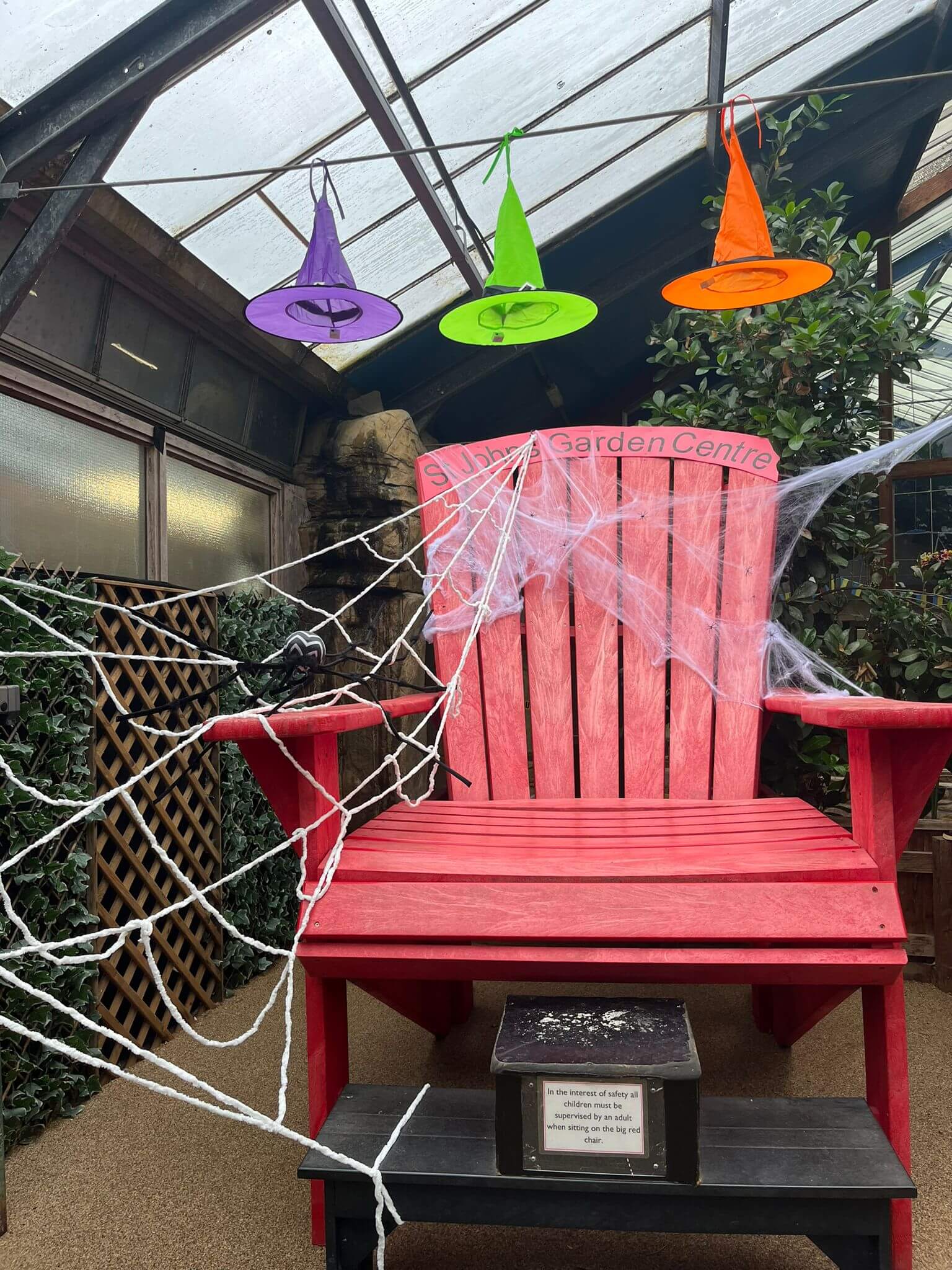 The big red chair topped with spiders webs and witches hats